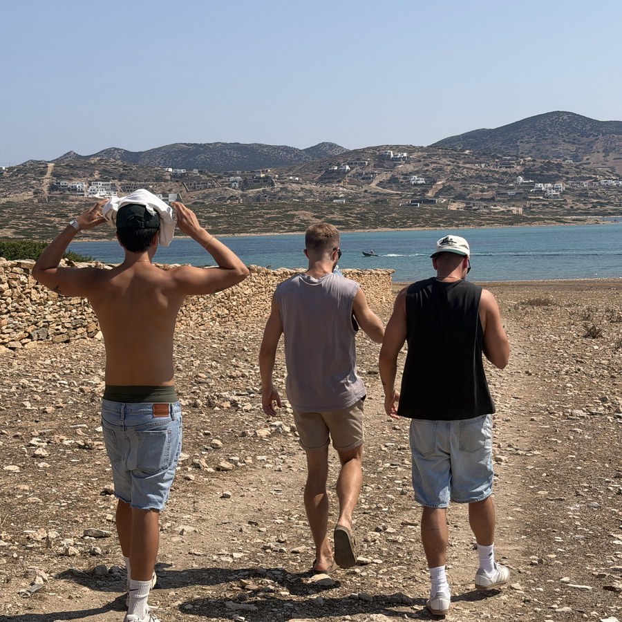 Three of the group walking a dirt track above the sea
