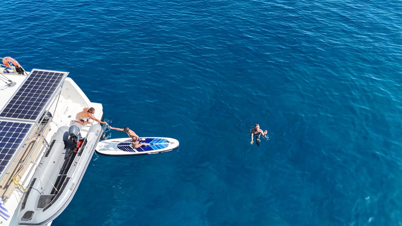 Paddleboarding and swimming off the back of the catamaran