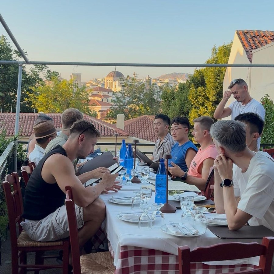 The group at a long table on a rooftop at golden hour